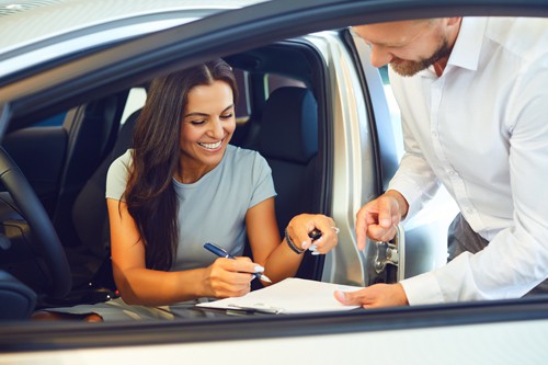 female-shopper-signing-finance-application-in-new-car